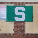 A Michigan State flag is seen pinned over boarded up windows of a tornado-damaged home in the Huron Farms subdivision in Dexter on Monday. Melanie Maxwell I AnnArbor.com